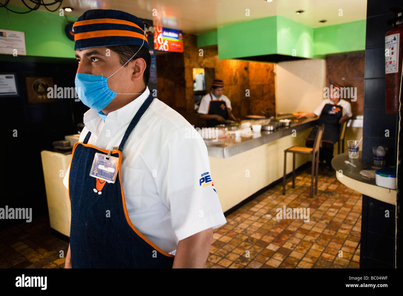 Ein Koch in einem Taco-Restaurant mit einer Maske in Mexico City, DF, Mexiko. Stockfoto