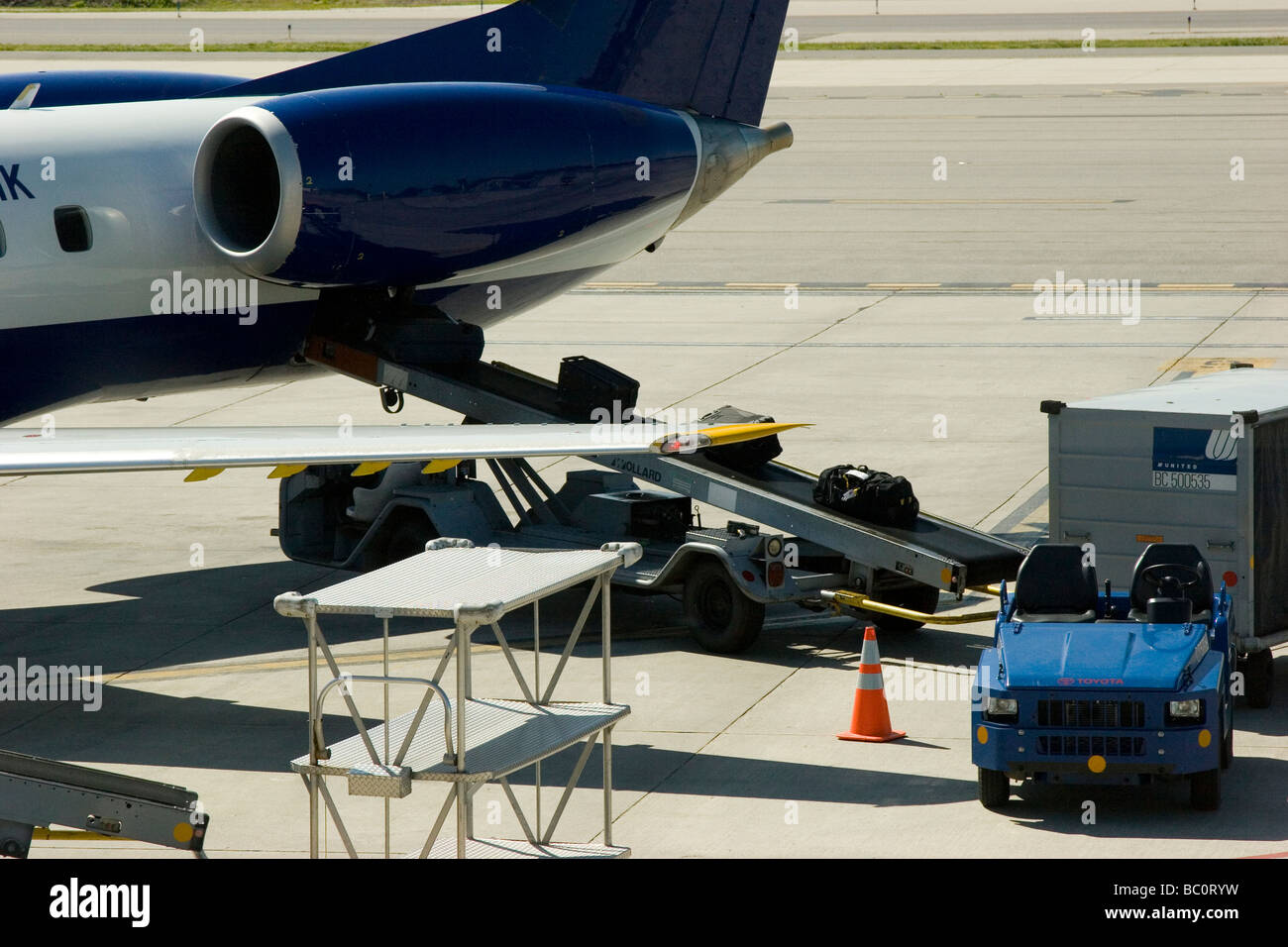 Flugzeug auf Asphalt mit Gepäck geladen wird Stockfoto