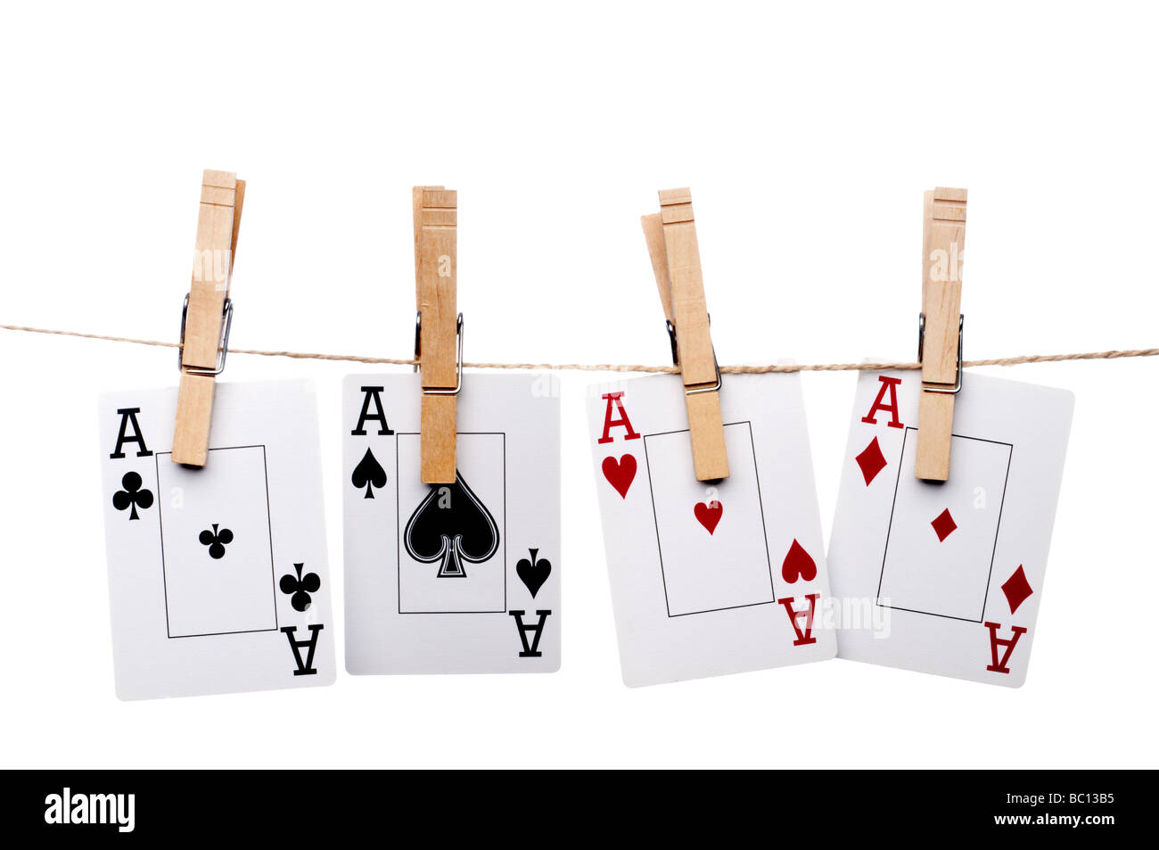 4 Ass Spielkarten von einer Wäscheleine hängen, auf einem weißen Hintergrund Stockfoto