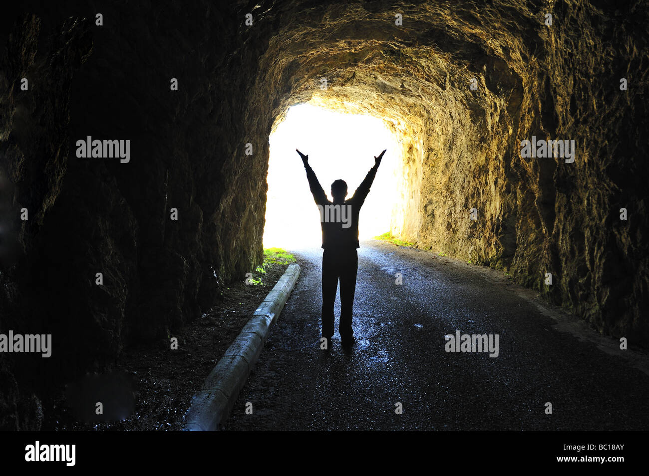 Licht am Ende des Tunnels. Silhouette einer Figur stehen am Ende eines dunklen Tunnels Blick auf hellem Tageslicht. Stockfoto