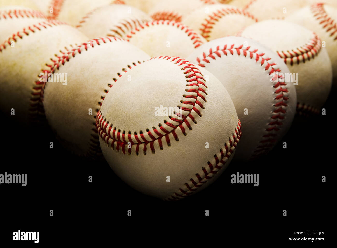Vorderansicht der Gruppe von gebrauchte abgenutzte Baseballs im Dreieck Anordnung Overhead Beleuchtung und selektive Focue Vordergrund angehoben Stockfoto