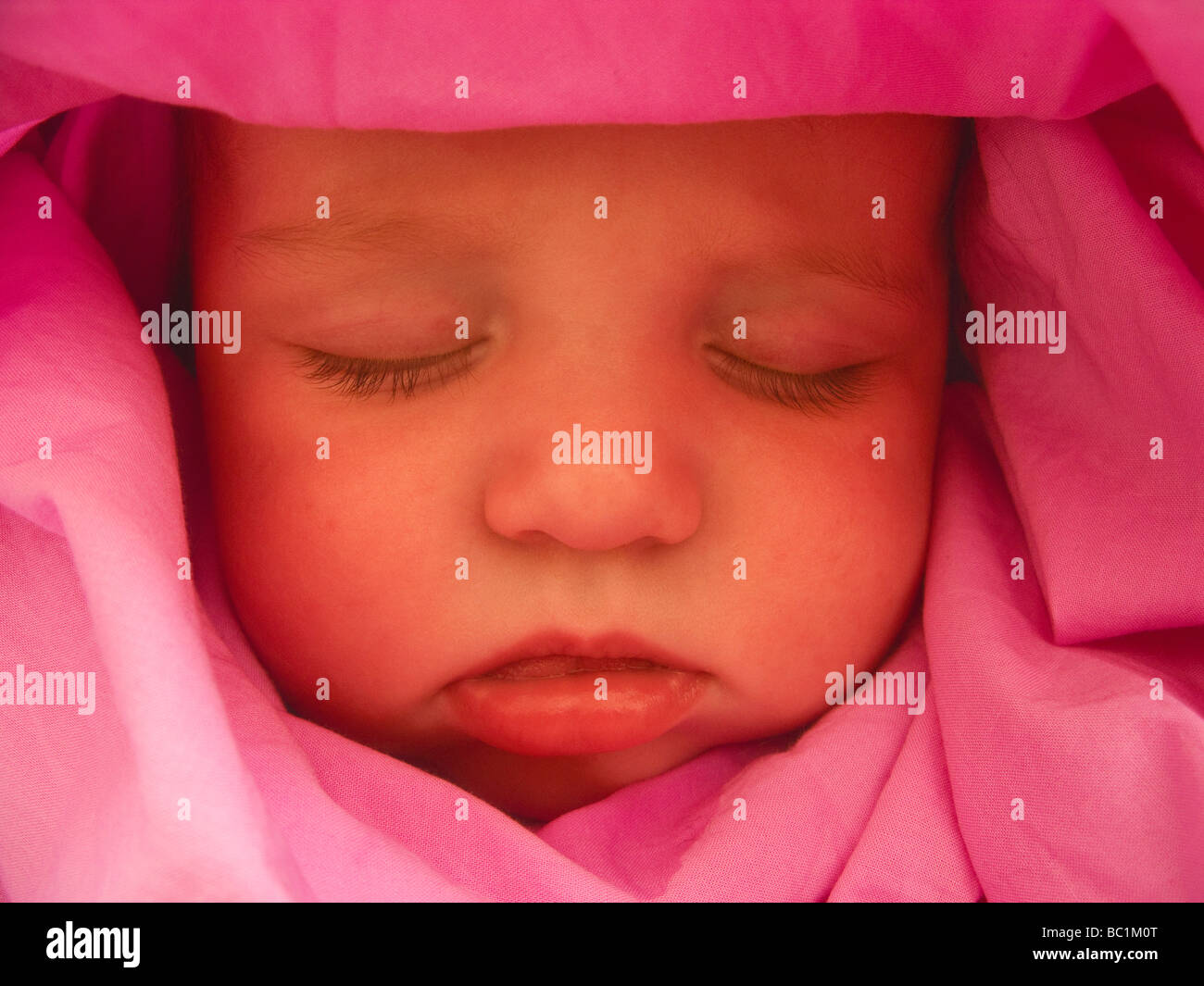 schlafenden Baby Boy mit rosa Tuch um den Kopf drapiert Stockfoto