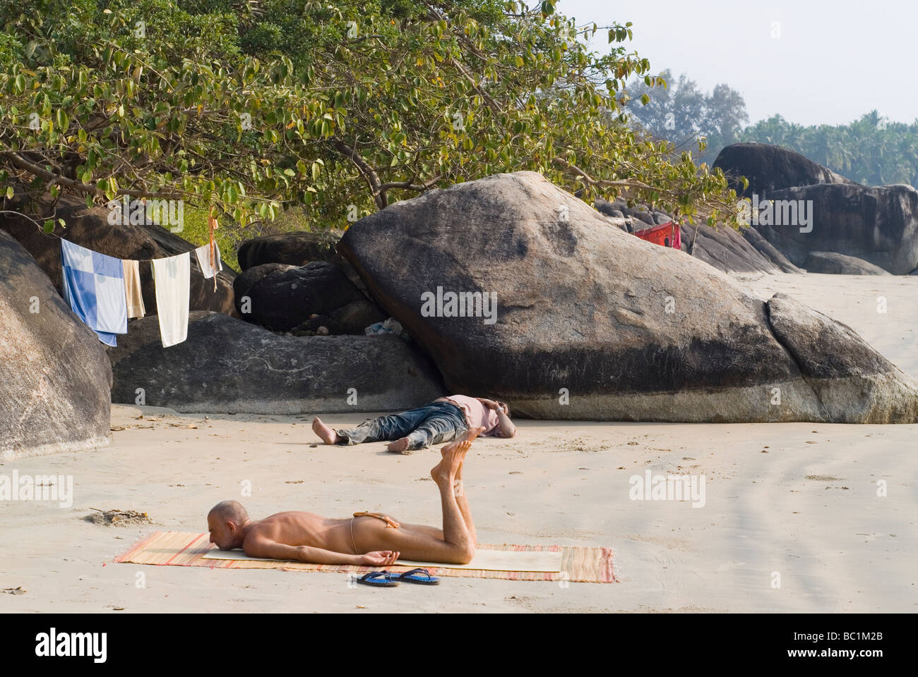 Ein Yogi und ein betrunkener Mann am Strand liegen. Palolem Beach, Goa, Indien. Sadhu und betrunken Mann. Stockfoto