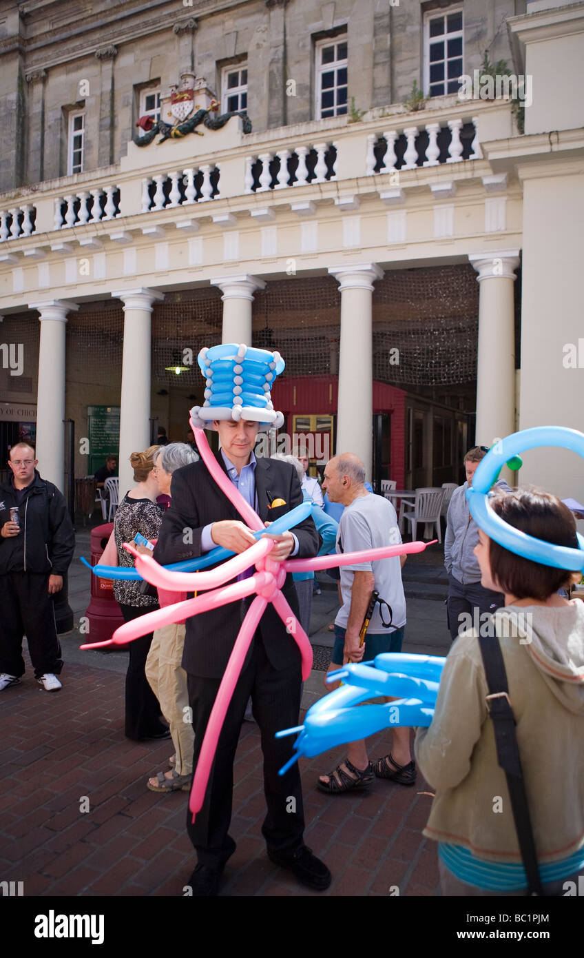 Streetunterhalter, der für Kinder aus Ballons Formen macht. Chichester, Großbritannien Stockfoto