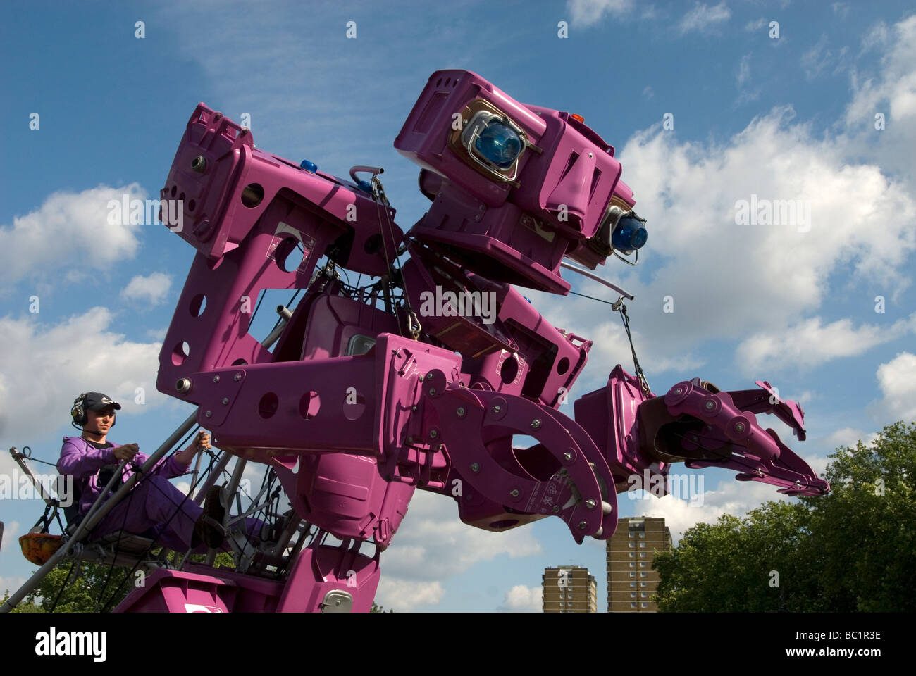 Riesige Motor gesteuert Roboter aus rosa Müll oder Mülltonnen zu fördern recycling im Park vor Hochhäusern gemacht Stockfoto