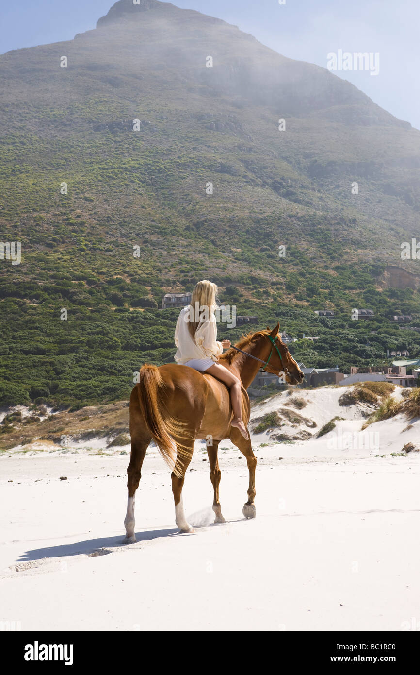 Mittleren Erwachsenenalter Frau Reiten am Strand Stockfoto