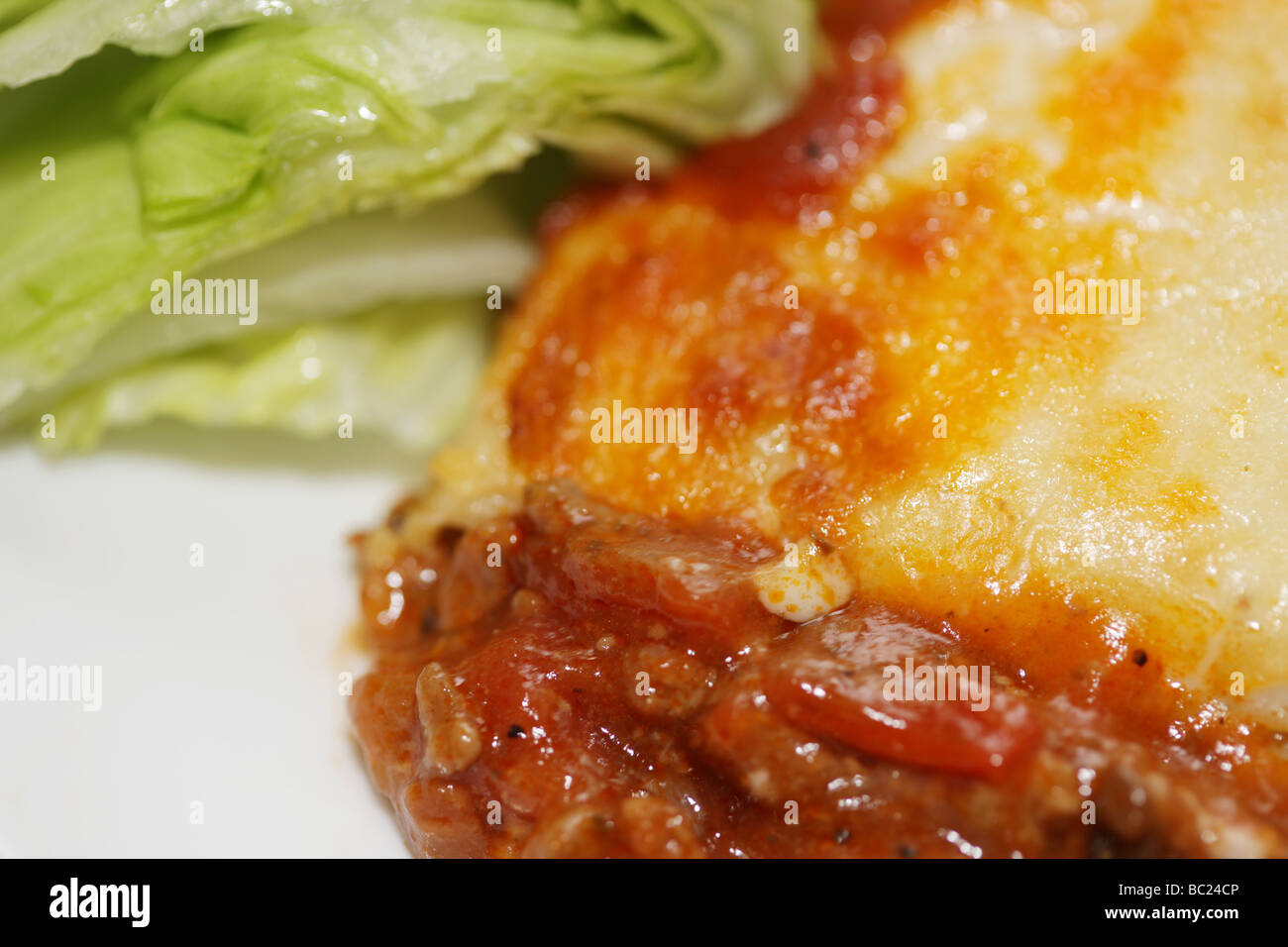 Frische leckere italienische Stil herzhaftes Hackfleisch Lasagne Pasta Essen gekrönt mit geschmolzenem Käse ohne Menschen und ein Salat auf Teller serviert Grnish Stockfoto