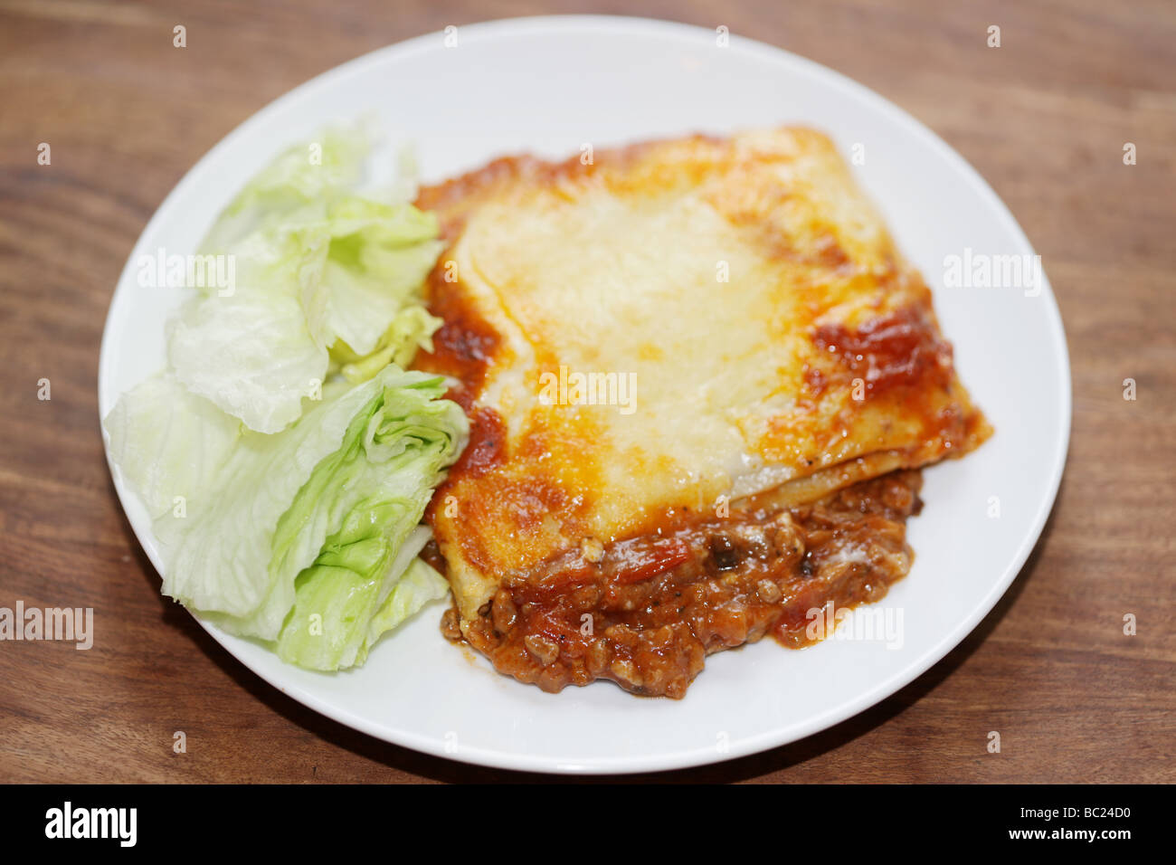 Frische leckere italienische Stil herzhaftes Hackfleisch Lasagne Pasta Essen gekrönt mit geschmolzenem Käse ohne Menschen und ein Salat auf Teller serviert Grnish Stockfoto