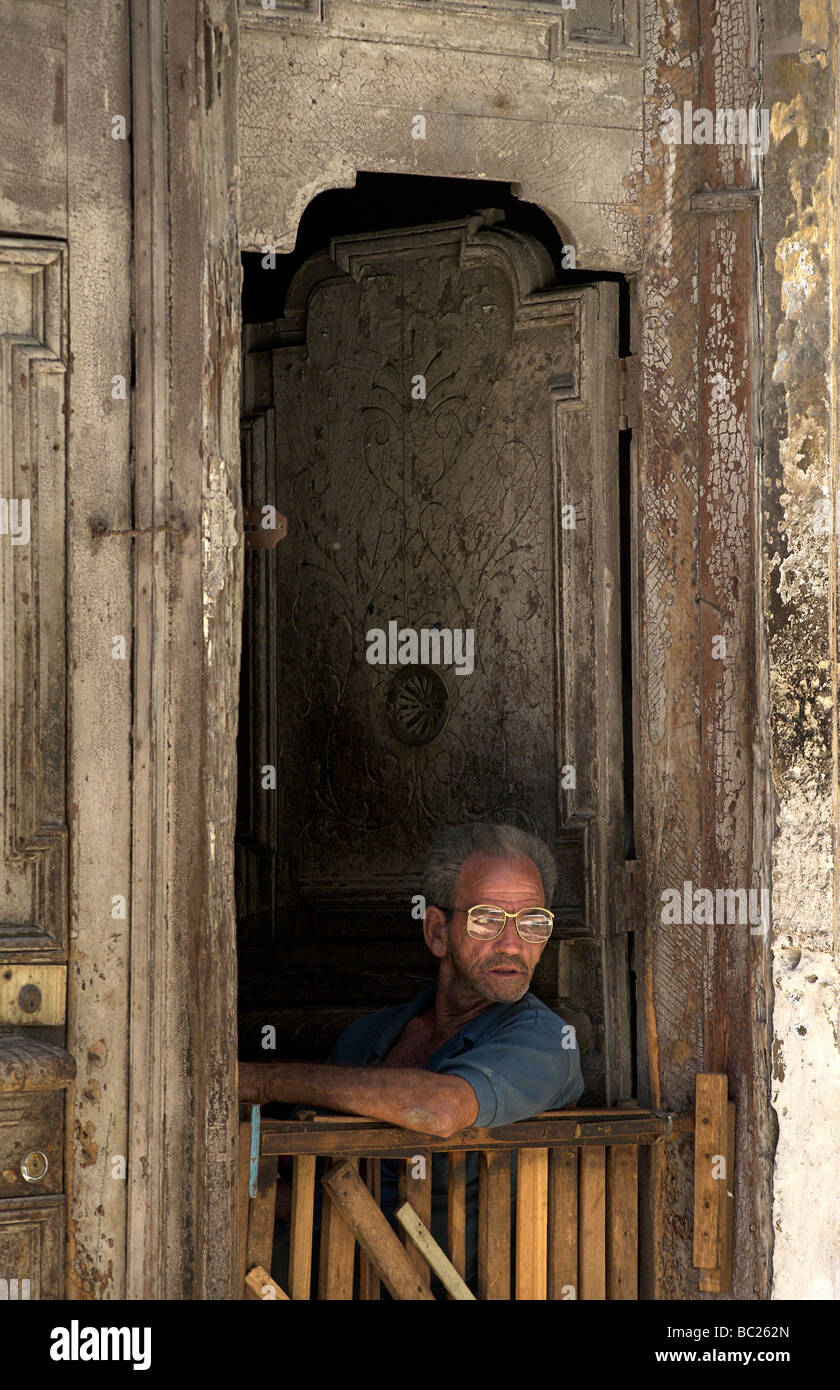 Kubanische Mann sitzt in der Tür zu seinem kolonialen Haus. Habana Vieja. Alt-Havanna, Kuba. Stockfoto