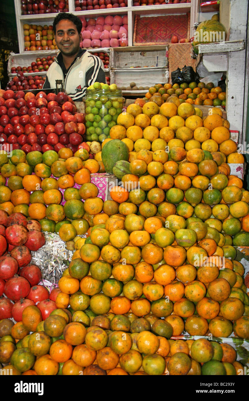 Indische Frucht Verkäufer umgeben von Orangen auf seinem Marktstand, Dibrugarh, Assam Stockfoto