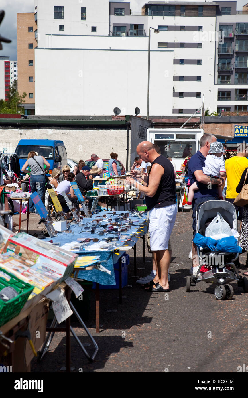 Potenzieller Kunde Sonnenbrille Prüfung auf einen Stall in Glasgow's berühmt/berüchtigten Barras market. Stockfoto