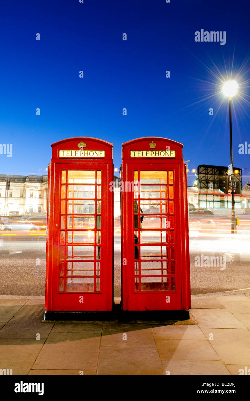 Rote Telefonzellen in der Nacht neben dem Trafalgar Square, London Stockfoto