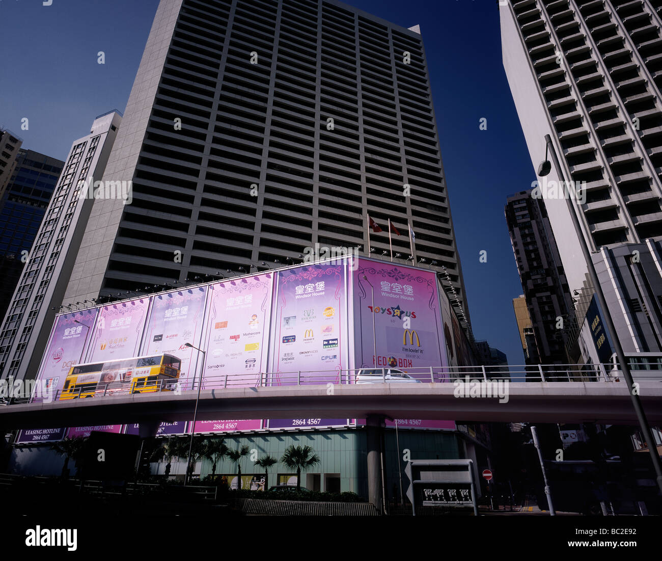 Gelben Doppeldecker-Bus vorbei an großen Plakatwänden auf einer Überführung in Hong Kong, China. Stockfoto