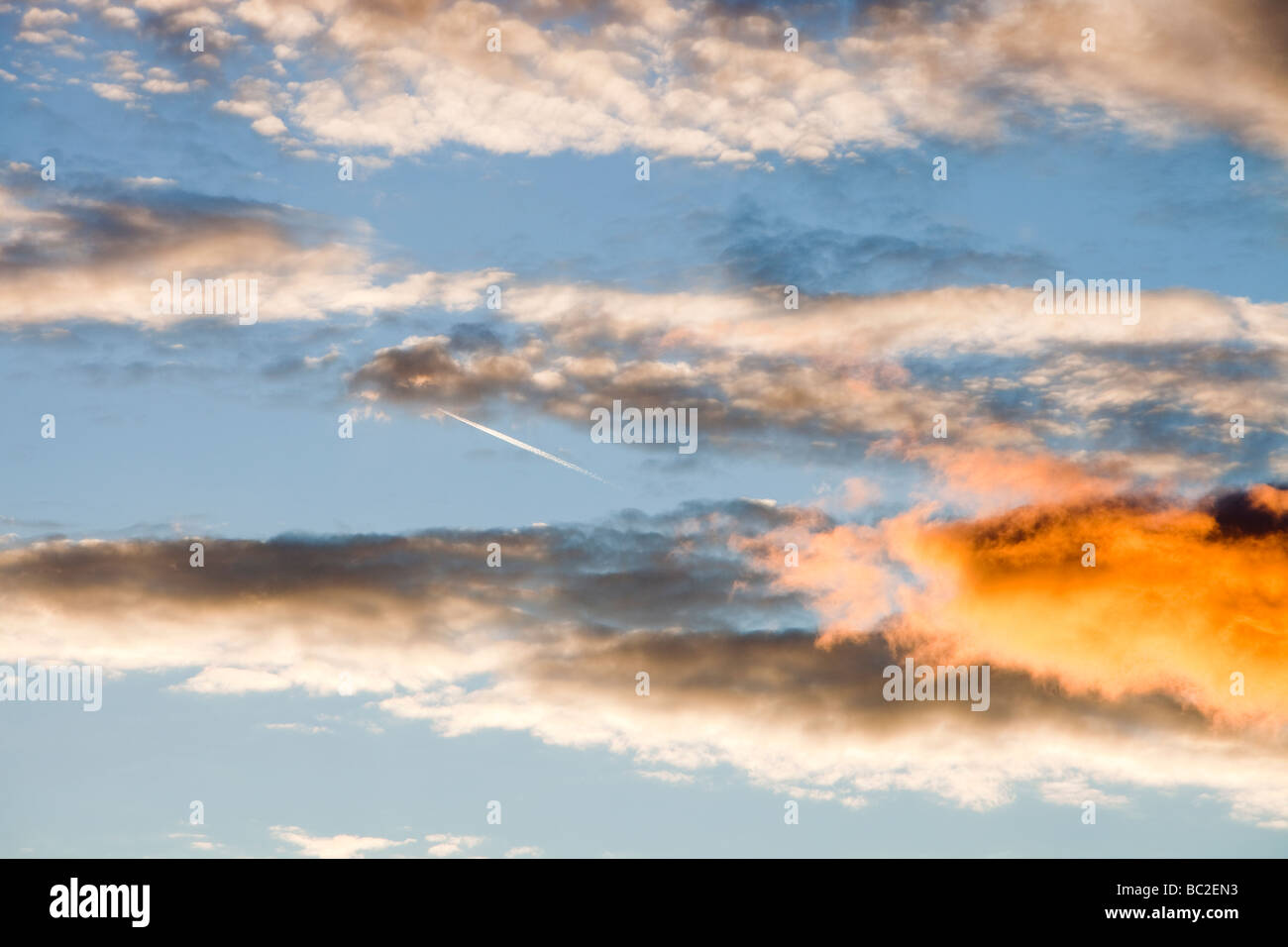 Ein Flugzeug fliegt durch Wolken bei Sonnenuntergang über Ambleside Cumbria UK Stockfoto