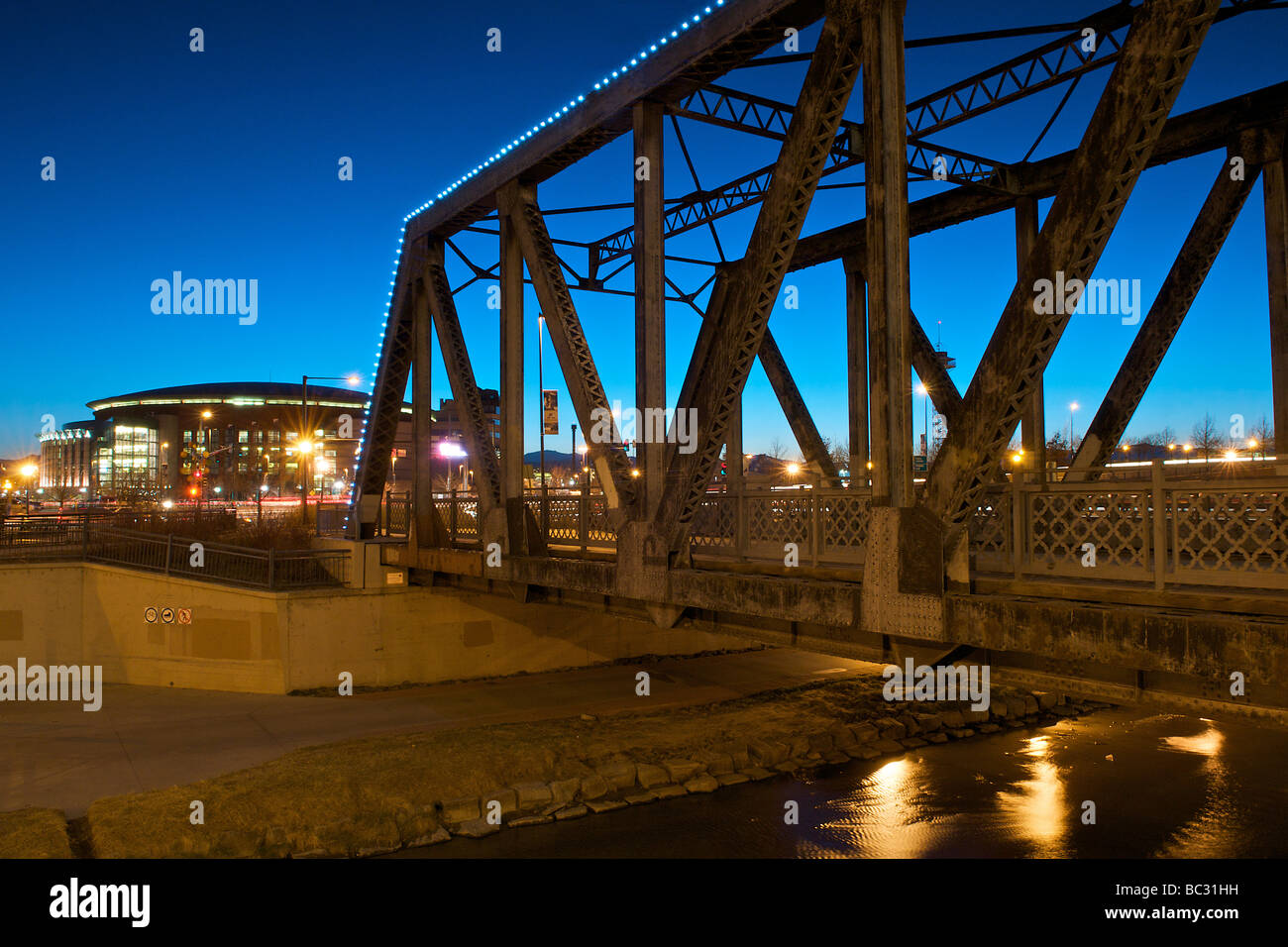 Autos, die über eine Brücke über einen Fluss auf dem Weg zu einer Sportarena. Stockfoto