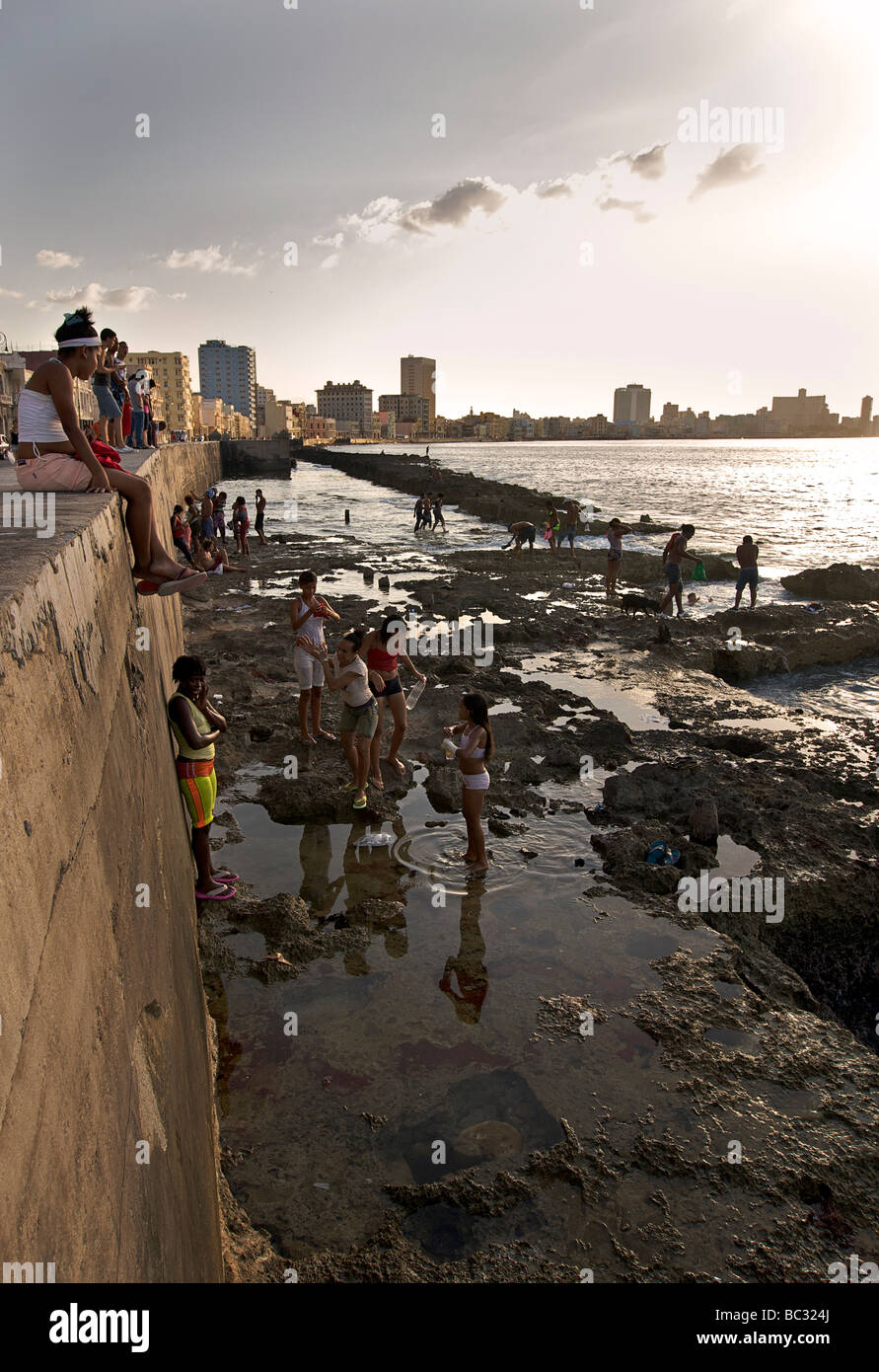 Kubaner genießen die Sonne und das Meer von den Felsen neben dem Malecon, Havanna, Kuba Stockfoto