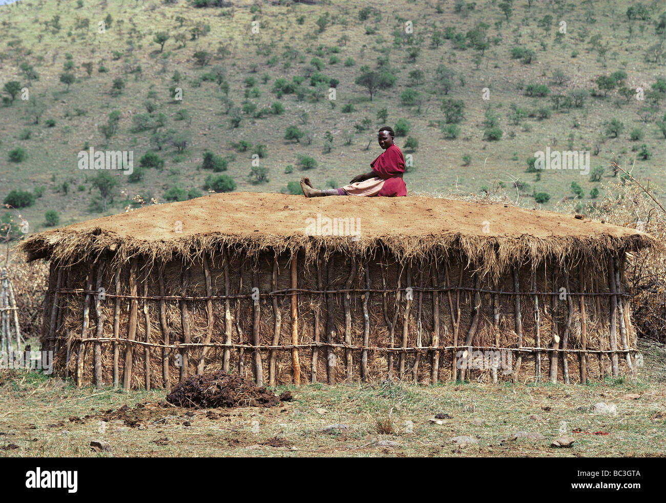 Massai Frau ruht auf ihrer Hütte nach abdecken mit frischem Kuhdung Masai Mara National Reserve Kenia Afrika Stockfoto