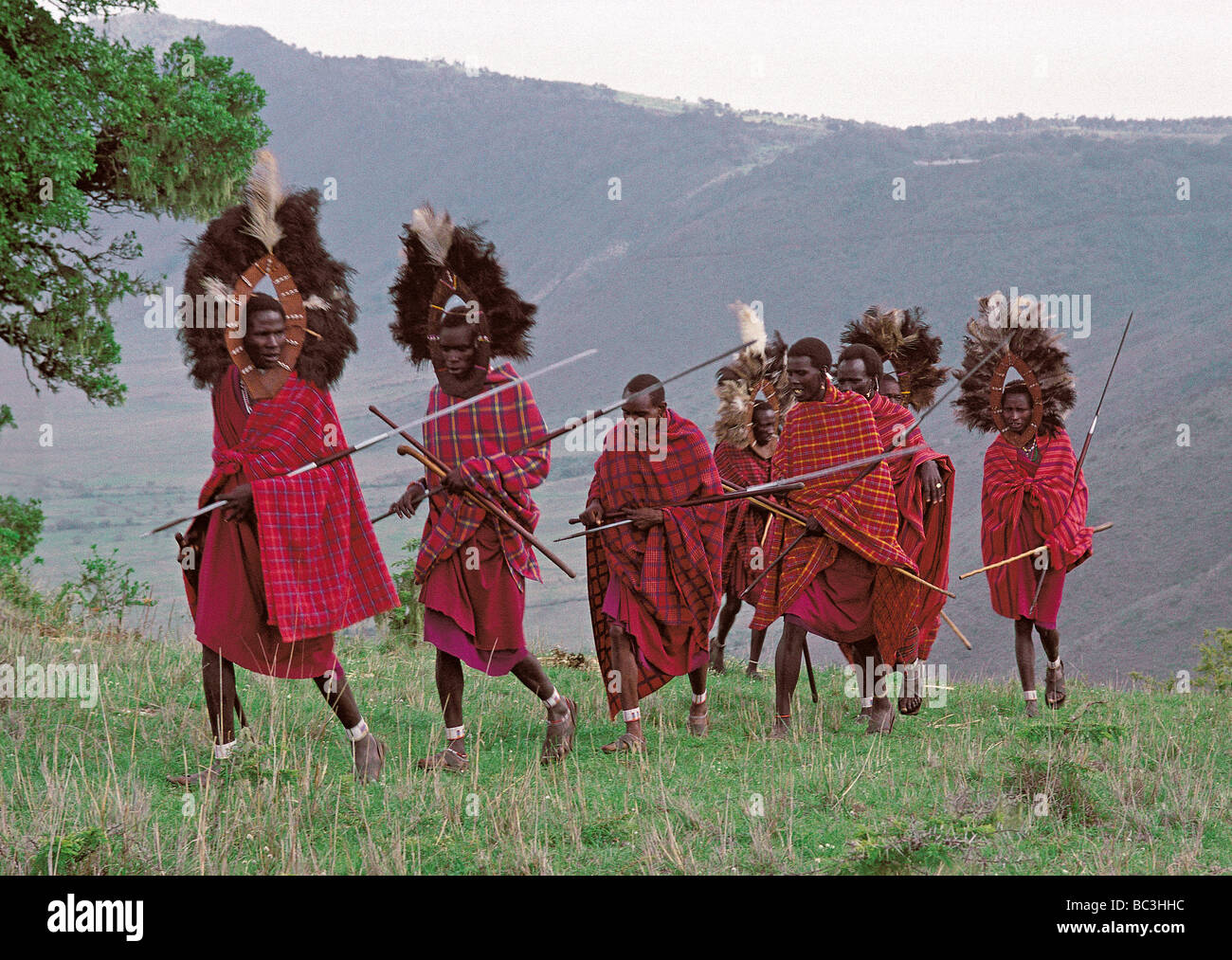 Eine Linie der Massai-Krieger oder Morani in traditioneller Tracht auf dem Rand des Ngorongoro Krater Tansania Ostafrika Stockfoto
