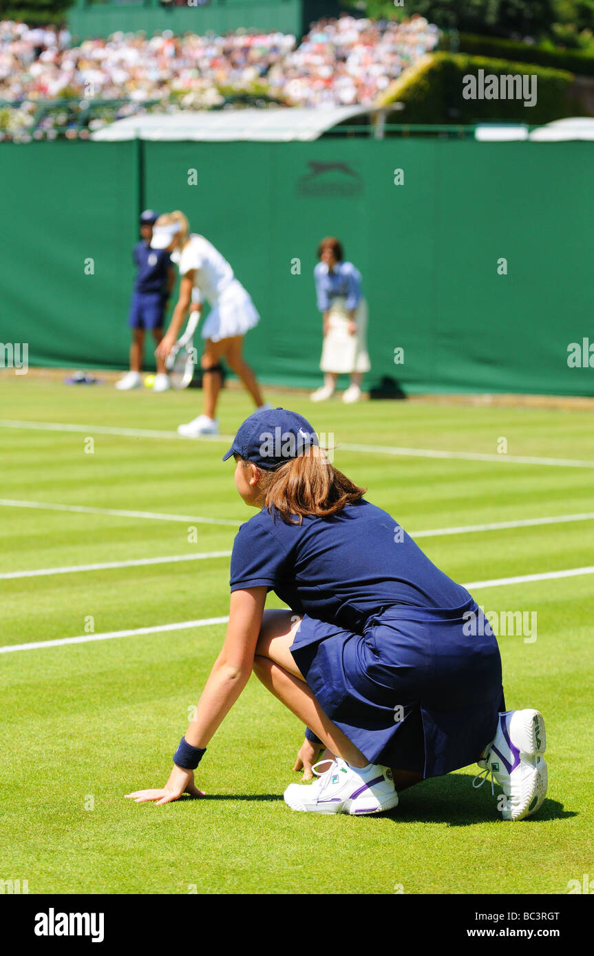 Ein Ball Mädchen schaut auf nimmt Russland s Maria Kirilenko auf Petra Kvitova in der ersten Runde der Damen-Einzel bei den Wimbledo Stockfoto