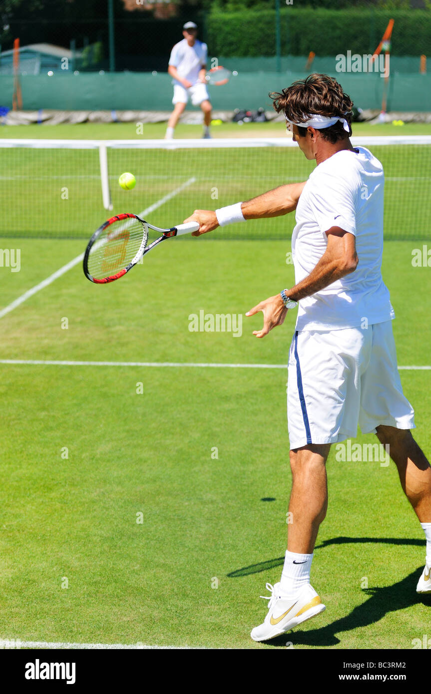 Schweizer Roger Federer spielt mit Sam Querry auf einem Übungsplatz während der 2009 Wimbledon Championships Stockfoto