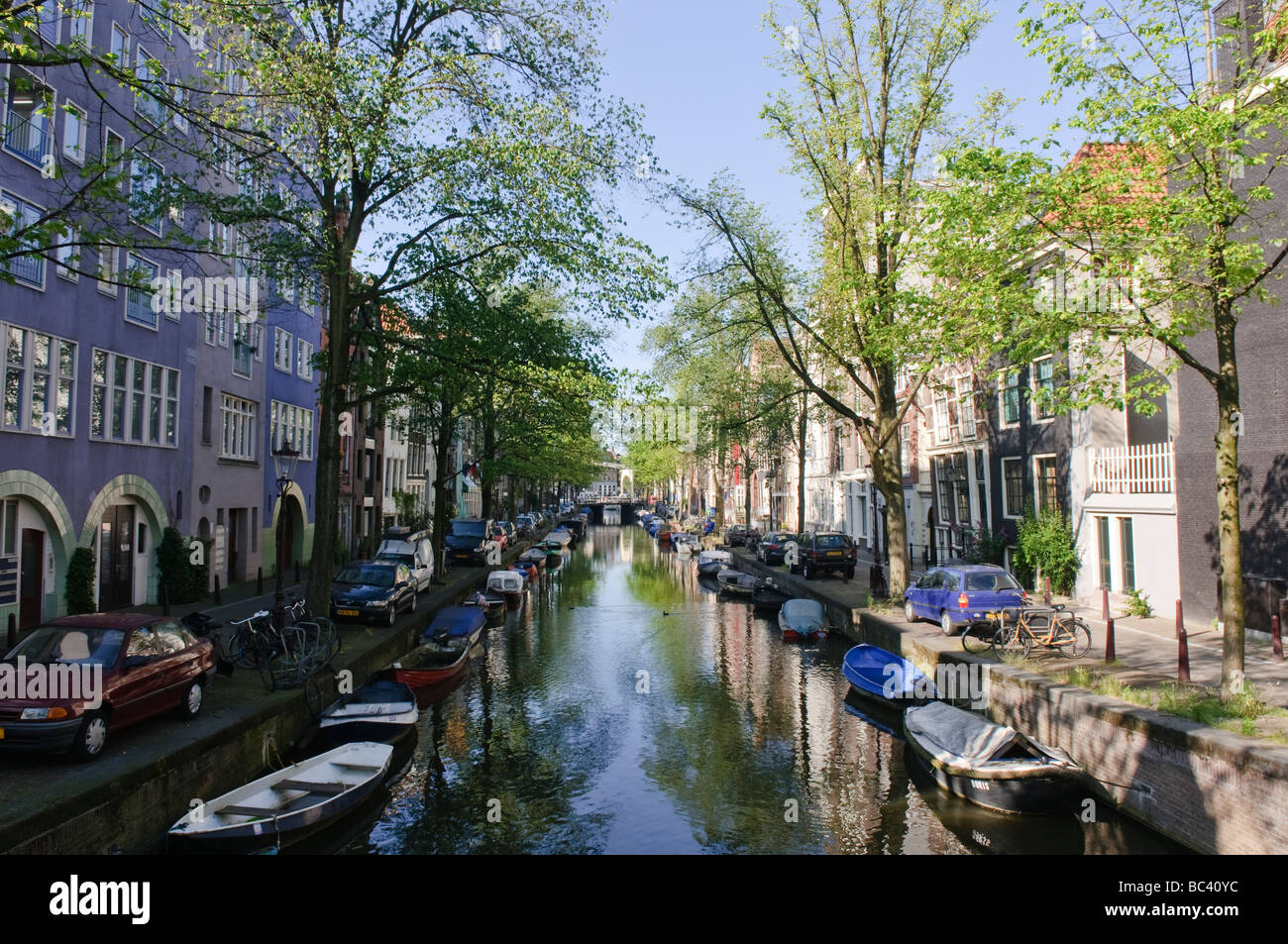 Boote, von Bäumen gesäumten Ufer eines Kanals in Amsterdam Stockfoto