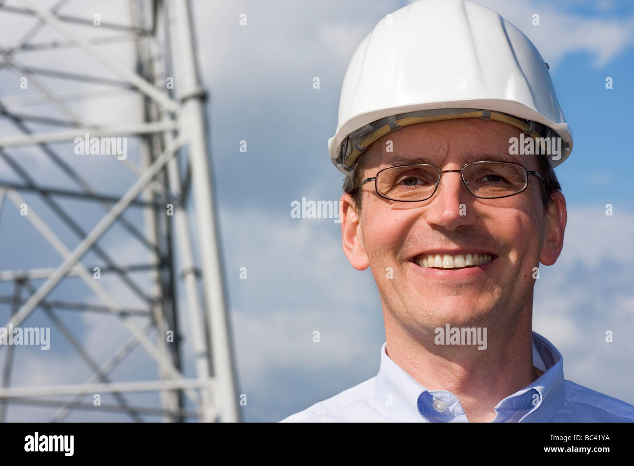 Lächelnder Ingenieur mit Bauarbeiterhelm auf Baustelle Stockfoto