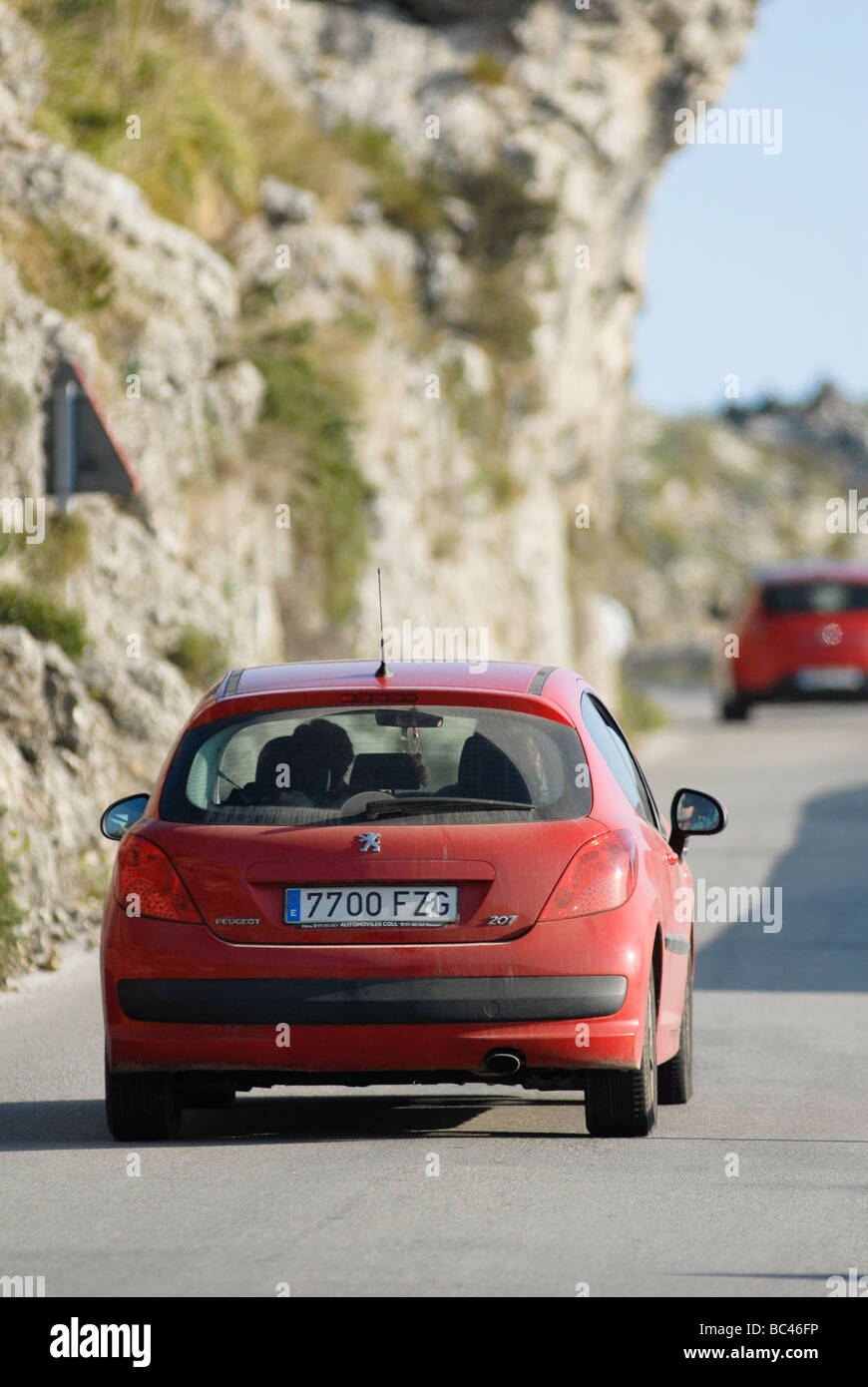 Rückansicht eines roten Peugeot 207 Autos fahren auf einer Straße in Spanien Stockfoto