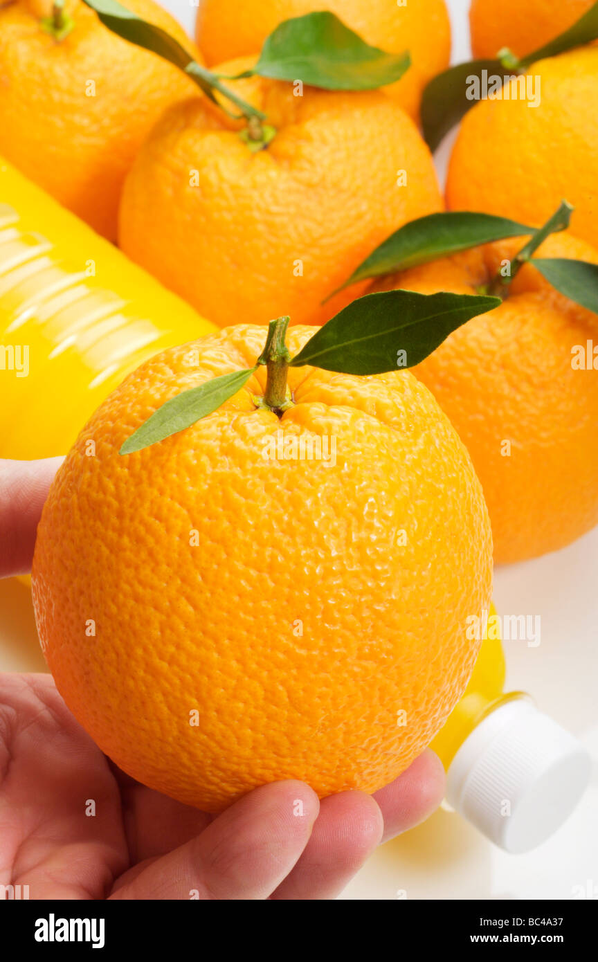 Orangen und eine Flasche Saft Stockfoto