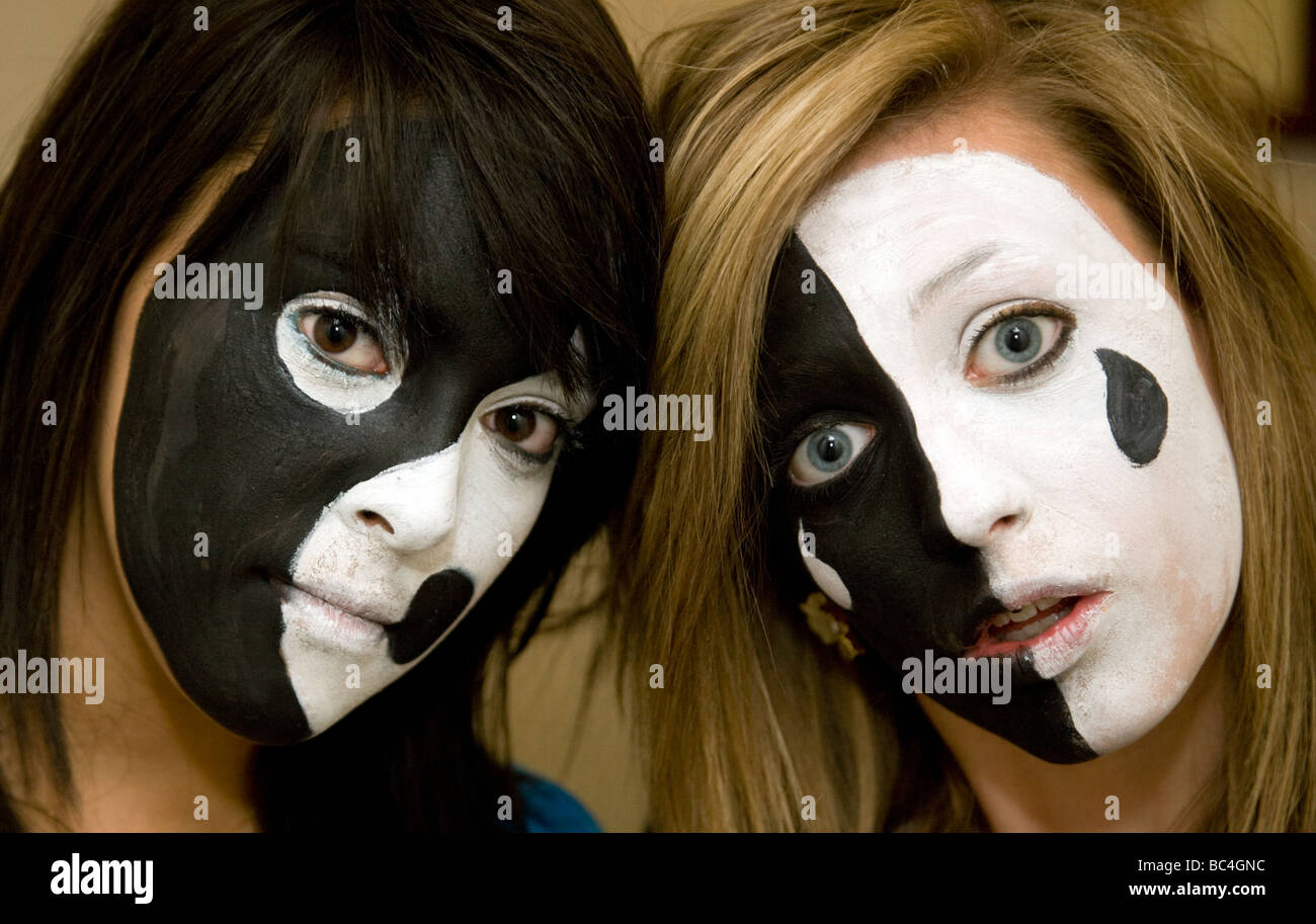 Zwei Mädchen im Teenageralter hatte ihre Gesichter in dramatischen Farben schwarz und weiß lackiert Stockfoto