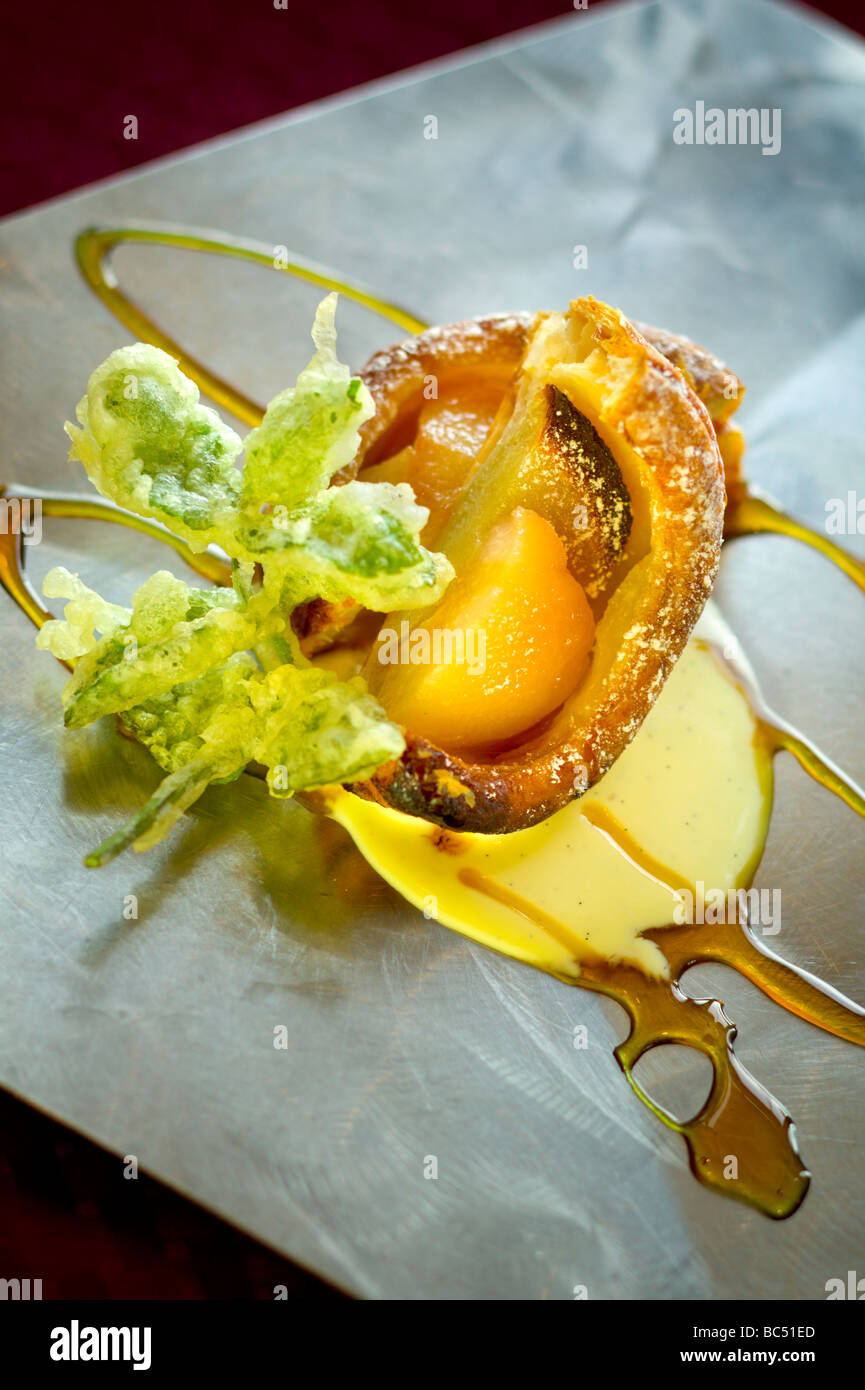 Ein dekadentes Dessert Apfel Pfirsich Tempura Schuster mit süßen Saucen auf einer Edelstahl-Platte Stockfoto
