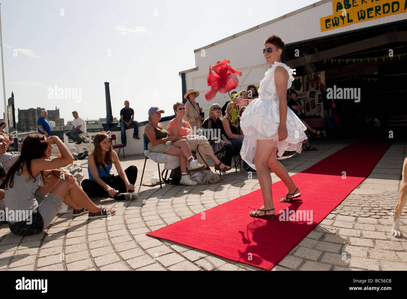 Eine Frau auf einem Laufsteg roten Teppich Modellierung Kleidung aus recycelten Stoffen Aberystwyth ist Green Festival Wales UK Stockfoto