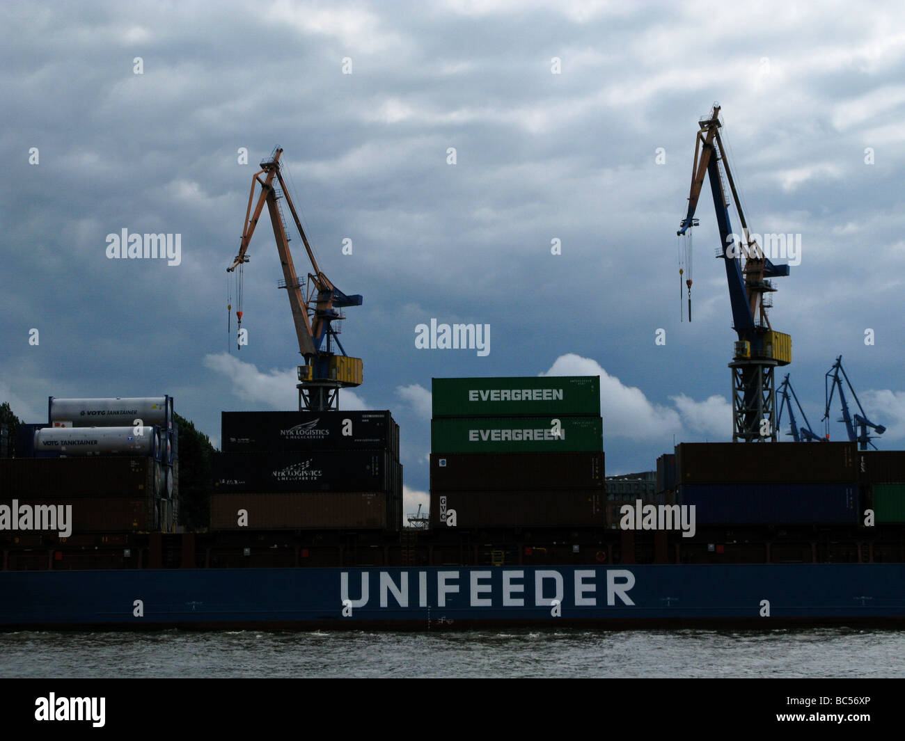 Unifeeder Containerschiff mit immergrünen Containern und Kränen in Hamburg Hafen Deutschland Stockfoto