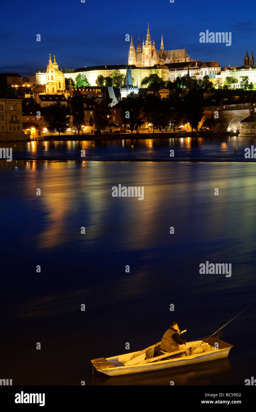 PRAG, Tschechische Republik - Prager Burg in der Dämmerung mit Reflexion auf der Moldau. Die berühmte Prager Burg, ein Symbol der tschechischen Geschichte und Macht, steht majestätisch auf einem Hügel mit Blick auf die Stadt. Es ist die größte antike Burg der Welt und ein UNESCO-Weltkulturerbe, das jedes Jahr unzählige Besucher anzieht, um die fesselnde Geschichte und architektonische Vielfalt zu erkunden. Stockfoto