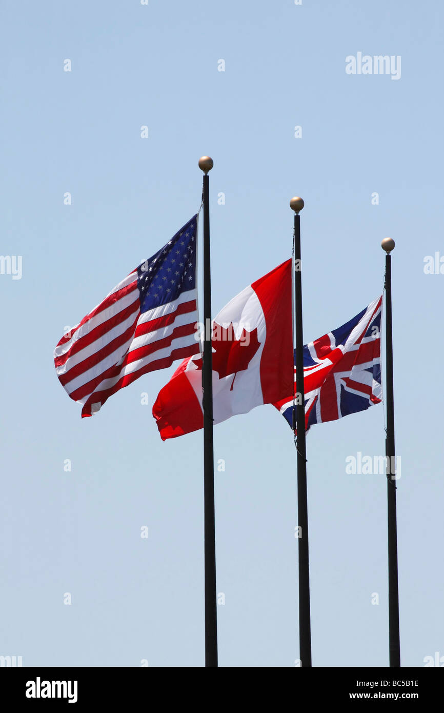 Fahnen USA britischer Kanadier auf einem Pfosten vor blauem Himmel niedriger Winkel Ausschnitt Ausschnitt isolierter Hintergrund in Ohio USA USA niemand vertikal hochauflösende Stockfoto