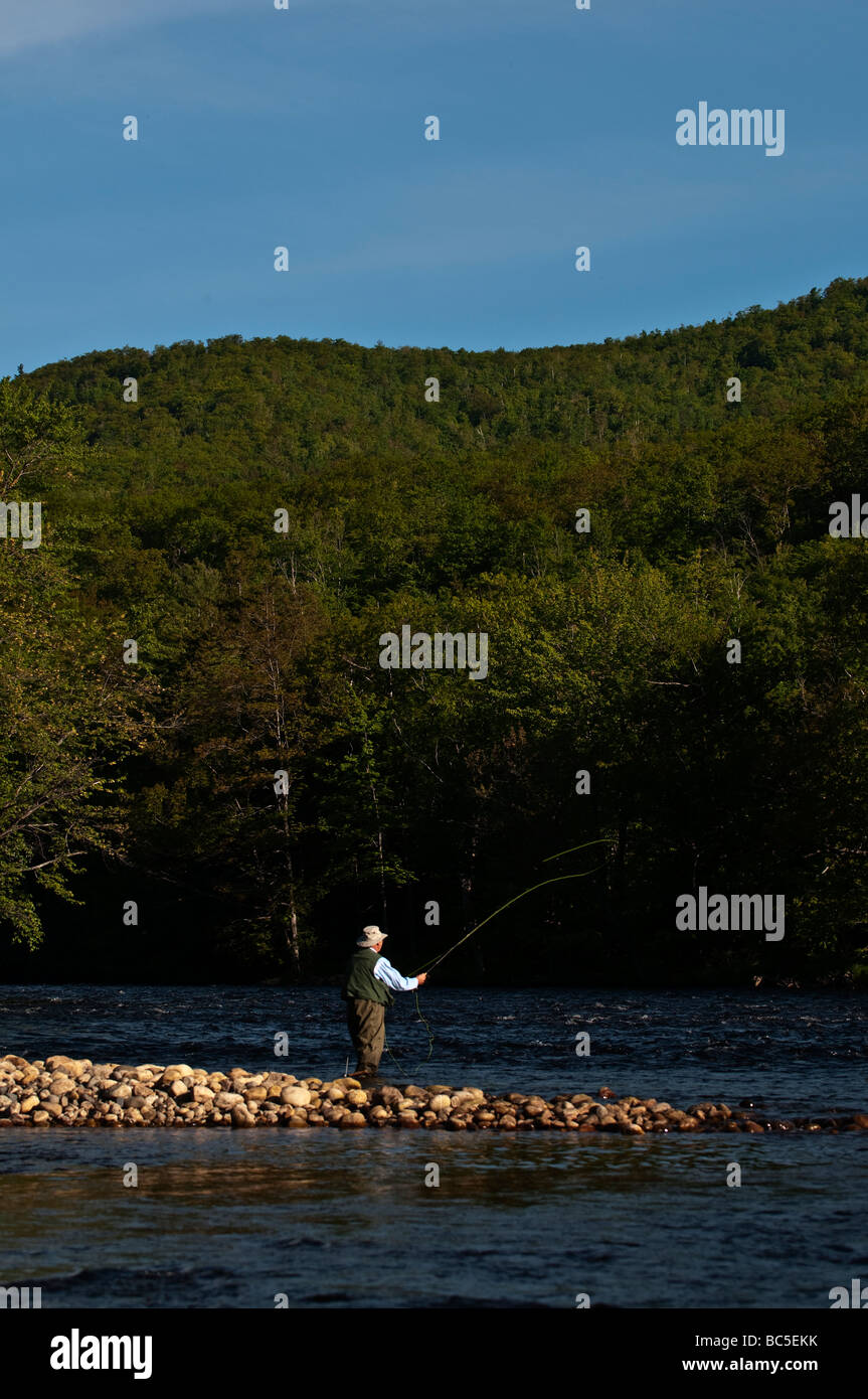 66 Jahre alten Fischer an der felsigen Küste des Androscoggin River in NH, an einem schönen Frühlingsmorgen. Stockfoto