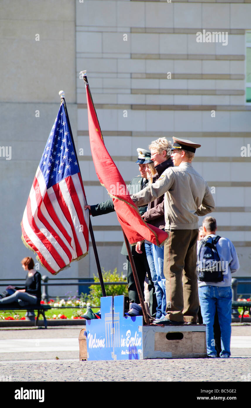 Schauspieler verkleidet als amerikanischer und sowjetischer Soldaten Pose für Fotos mit Touristen vor dem Brandenburger Tor in Berlin, einem der Wahrzeichen des Kalten Krieges. Stockfoto