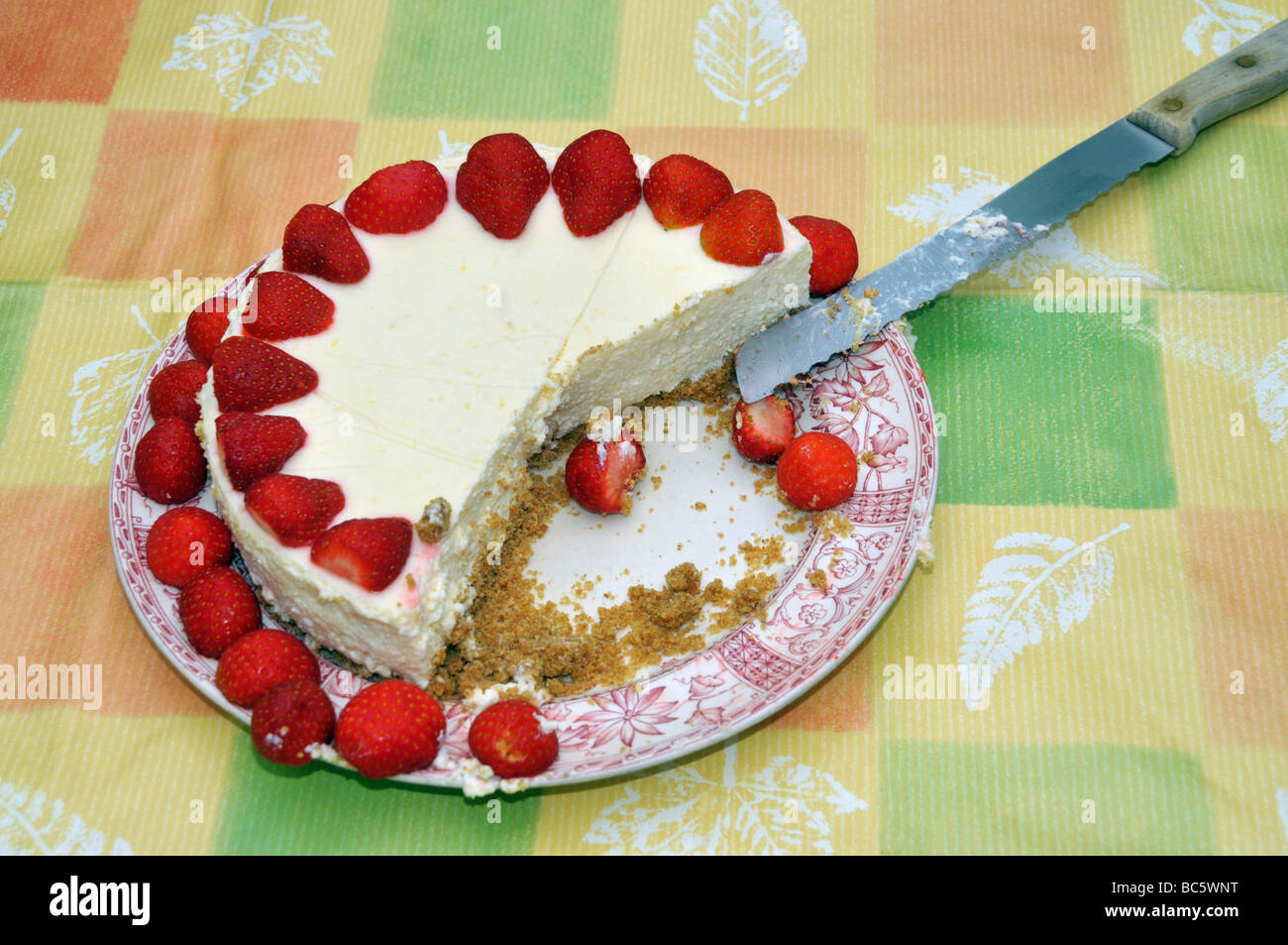Ein Erdbeer-Käse-Kuchen mit dienen / Messer schneiden. Stockfoto