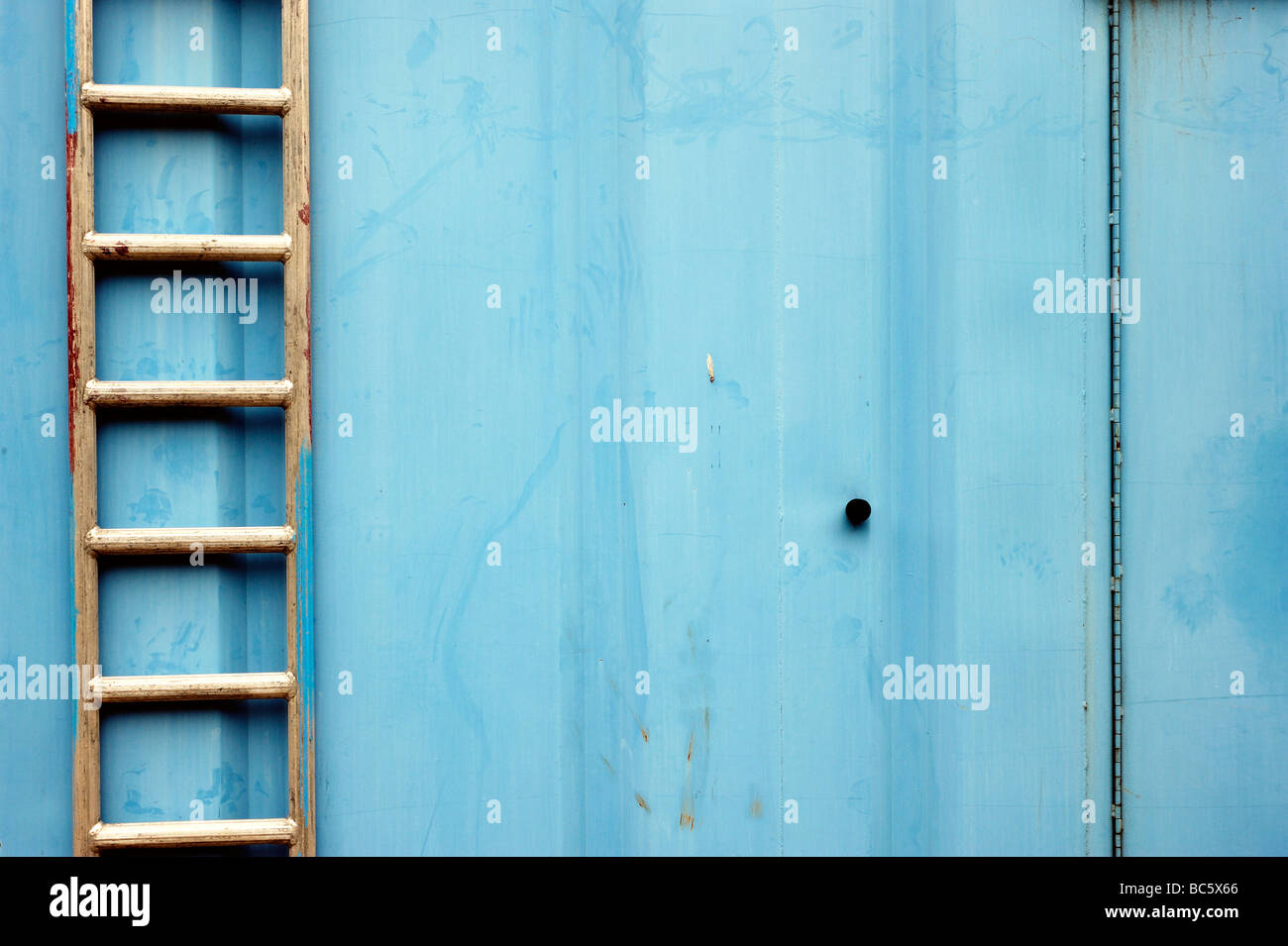 Leiter gegen eine blaue Struktur Stockfoto