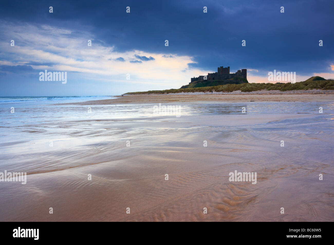 Eine stimmungsvolle Morgen am Strand von Bamburgh zeigt die Vorahnung Form von Bamburgh Castle Northumberland Küste Stockfoto