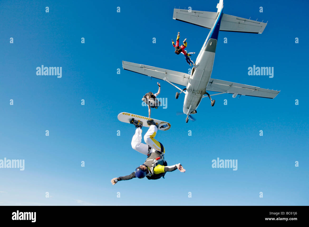 Vier Fallschirmspringer springen aus Propellerflugzeug, Schweiz Stockfoto