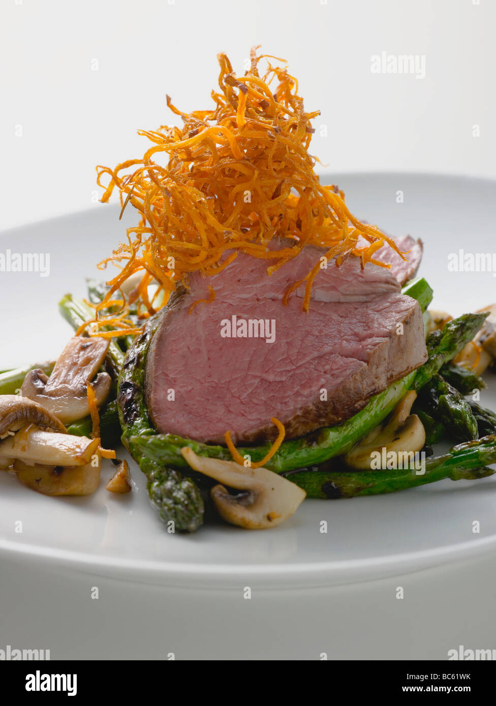 Rindersteak mit grünem Spargel und Champignons- Stockfoto