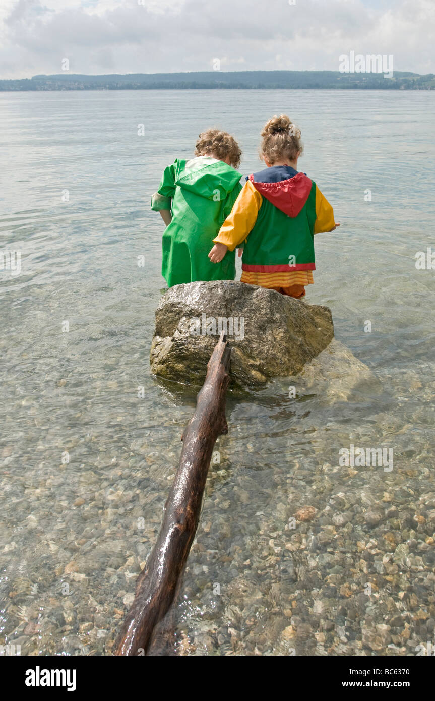 Deutschland, Baden-Württemberg, Bodensee, Kinder (3-5) stehen im Wasser, Rückansicht Stockfoto