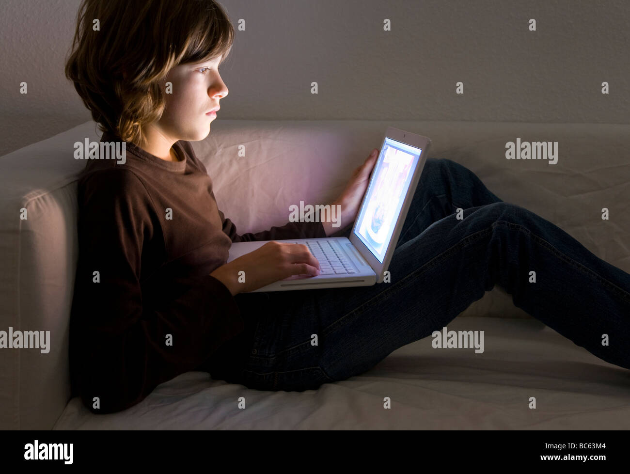 Junge (12 Jahre) arbeitet auf laptop Stockfoto