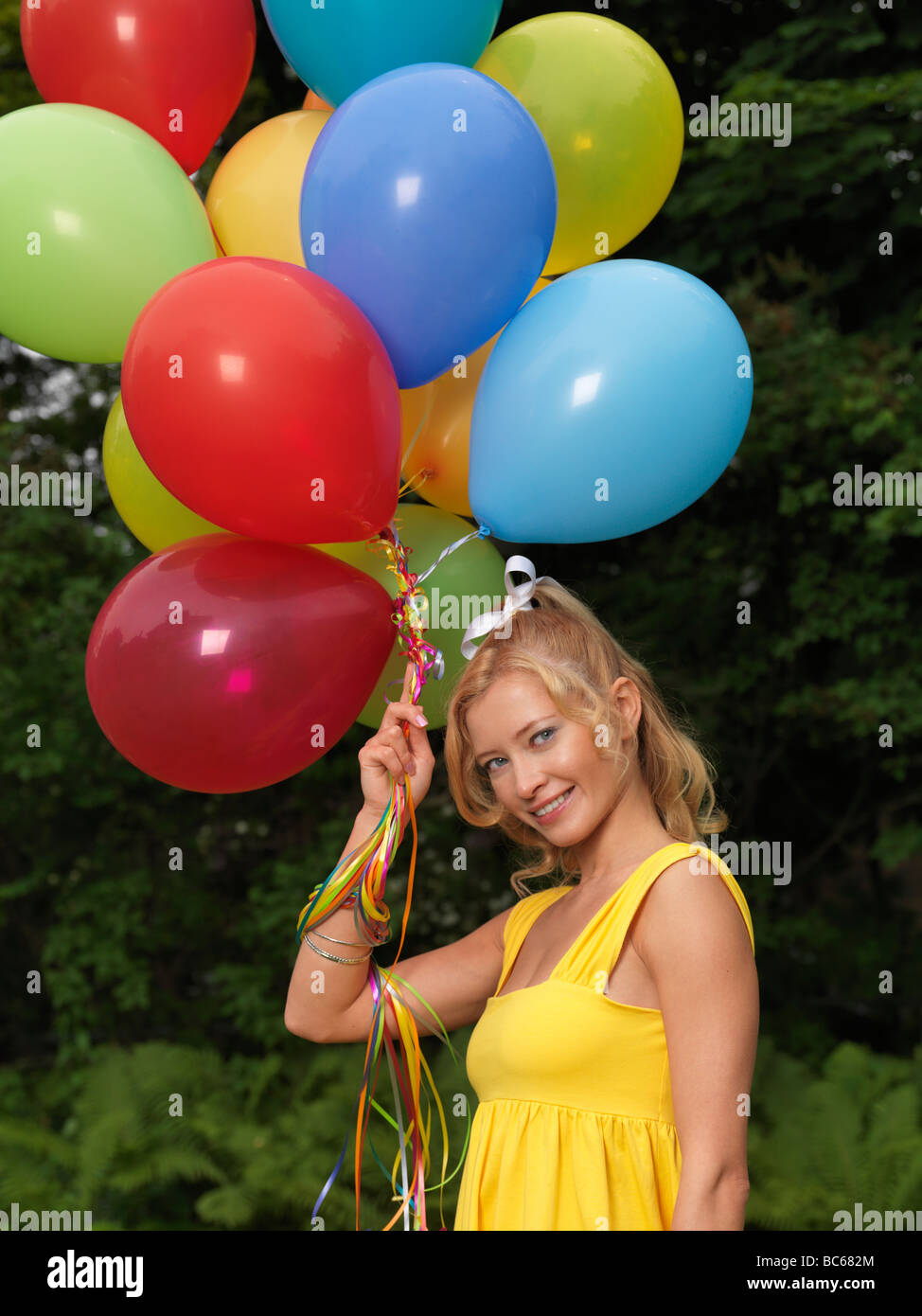 Glückliche Mädchen mit einer Reihe von bunten Luftballons Stockfoto