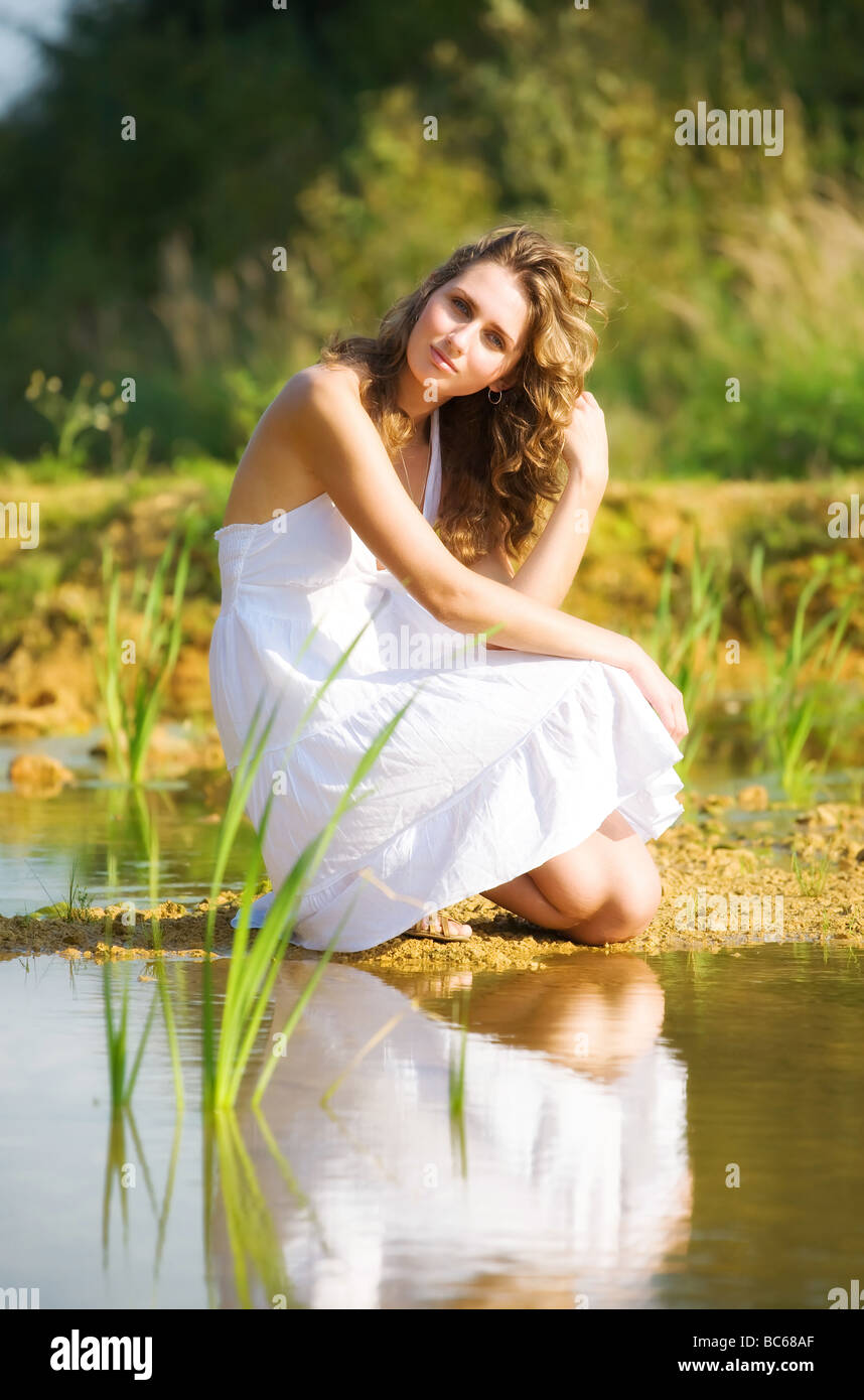 Junge, romantische Frau an einem Flussufer Stockfoto