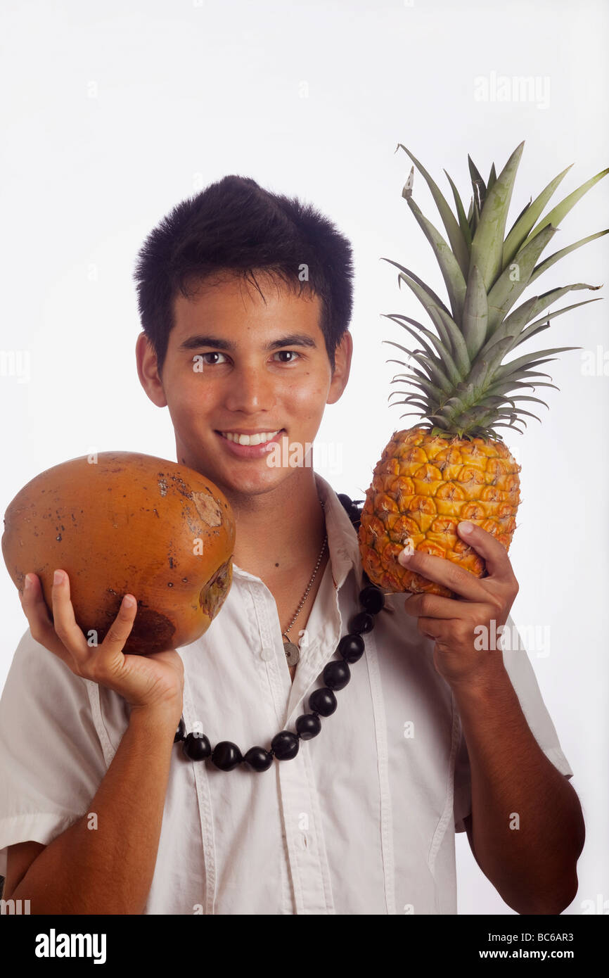 Hawaiian Mann trägt ein Lei Kukui Nuss hält eine Ananas und Kokosnuss Stockfoto