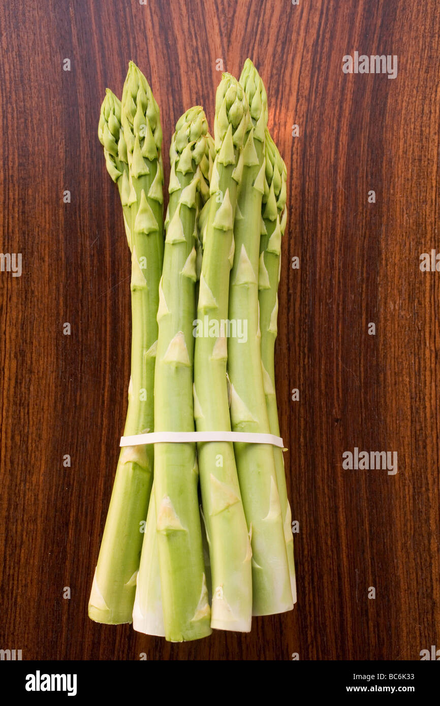 Ein Bündel grüner Spargel auf hölzernen Hintergrund- Stockfoto