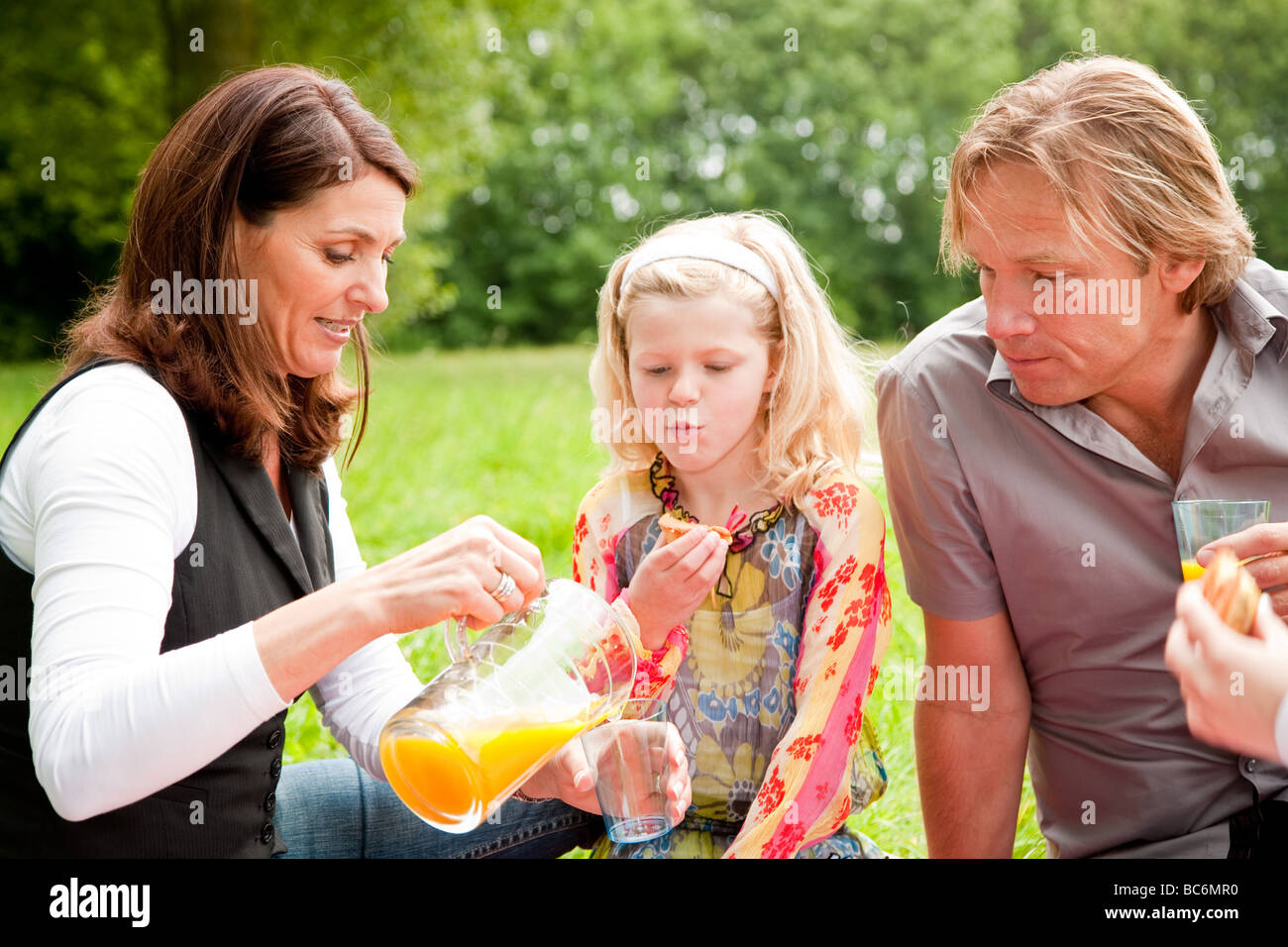 Junge hübsche Familie auf ein Picknick im Freien auf dem Gebiet Stockfoto