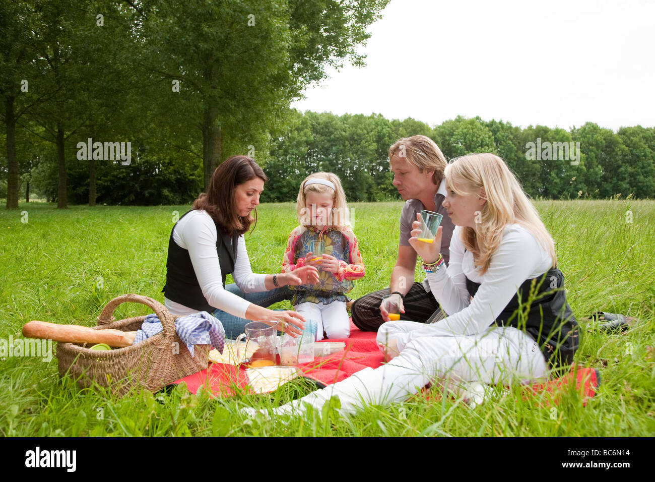 Hübsche junge Familie auf ein Picknick im Freien auf dem Gebiet Stockfoto