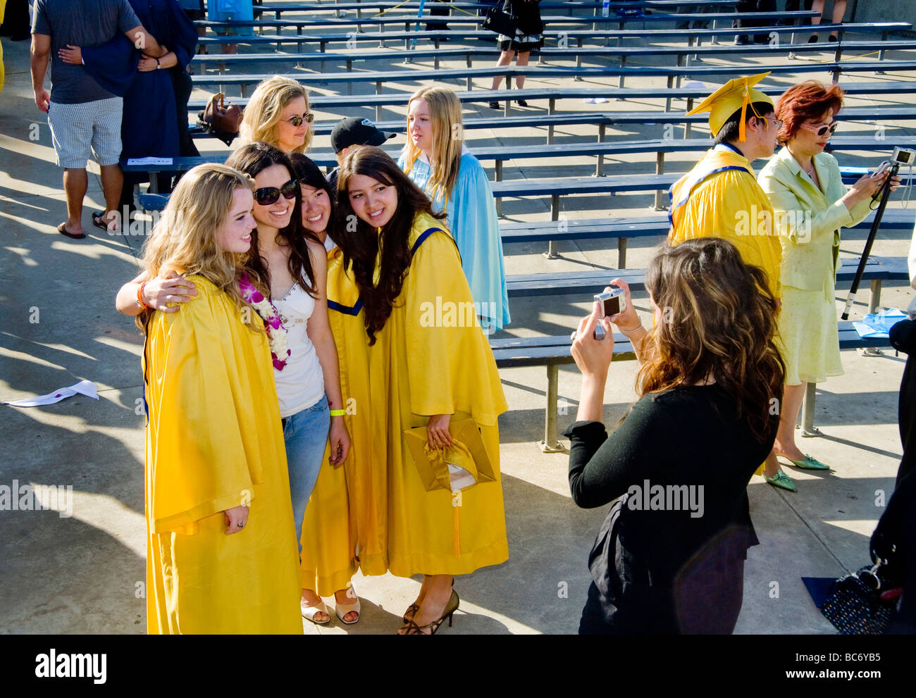 Glücklich graduierenden High School Seniors posieren für eine Familiengruppe Foto nach Outdoor-Abschlussfeier in Huntington Beach Kalifornien Stockfoto
